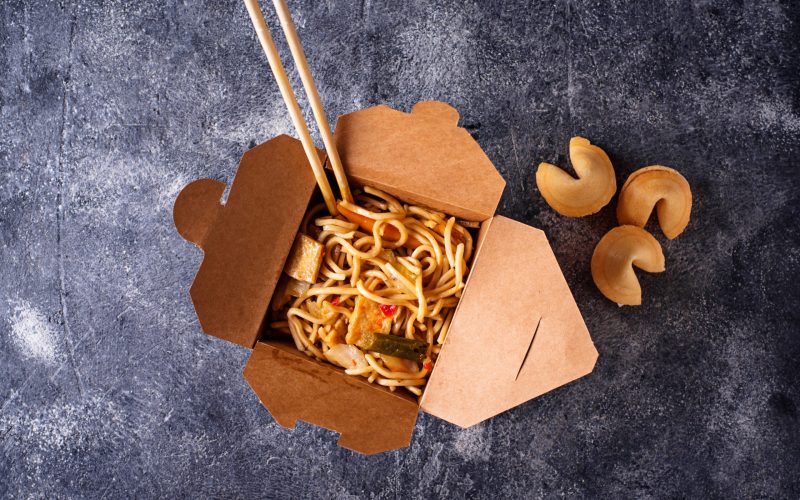 Box with traditional Asian noodles and fortune cookies